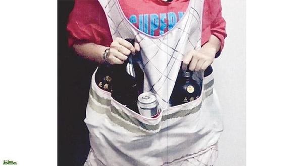 امرأة تهرب خموراً تحت عباءتها بمطار جدة امرأة تهرب خموراً تحت عباءتها