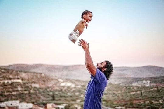 صورة تهز العالم .. طفل بلا اطراف يستجيب لمداعبات والده بضحكة صافية طفل 1