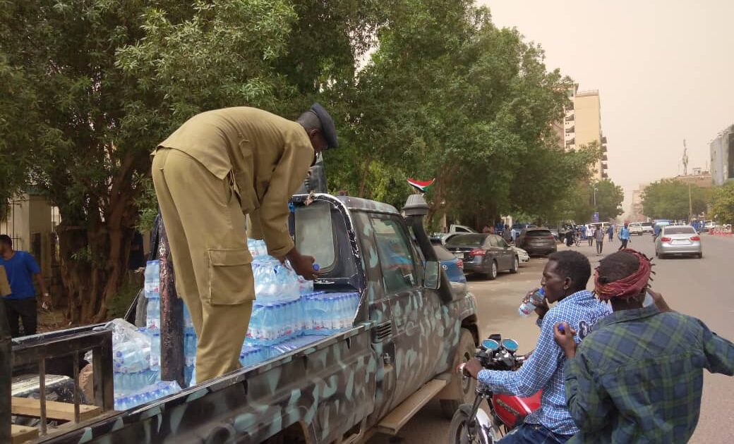 الشرطة السودانية توزع قوارير المياه في مسيرات ذكرى فض اعتصام القيادة IMG 20210603 WA0050