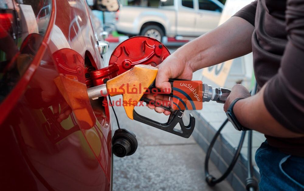 انخفاض اسعار الوقود في الخرطوم closeup man hands handle tool refueling gasoline pump into red car gas station work1