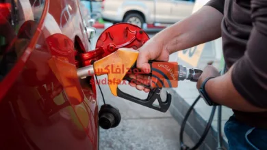 closeup man hands handle tool refueling gasoline pump into red car gas station work1 - كسلا ترفع سعر الجازولين